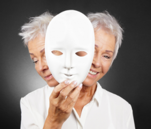 woman holding a white mask but looking both happy and sad.